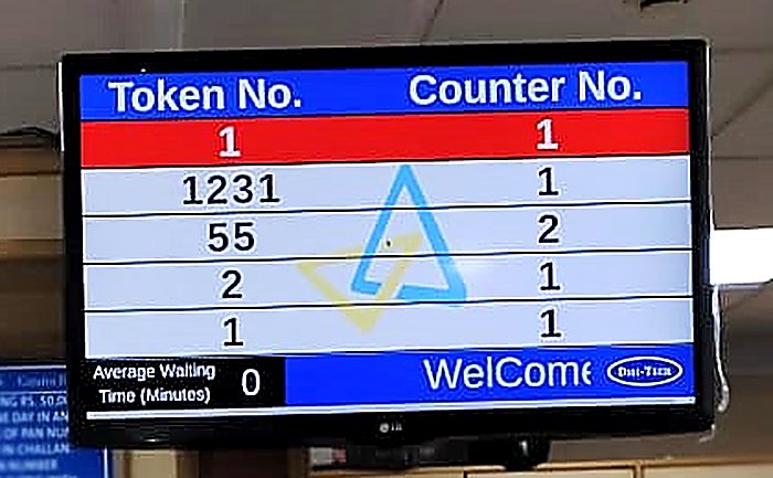 Bank queue display at a Canara Bank branch showing token and counter numbers with average waiting time